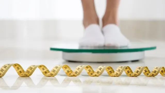 balança pessoa se pesando fita métrica