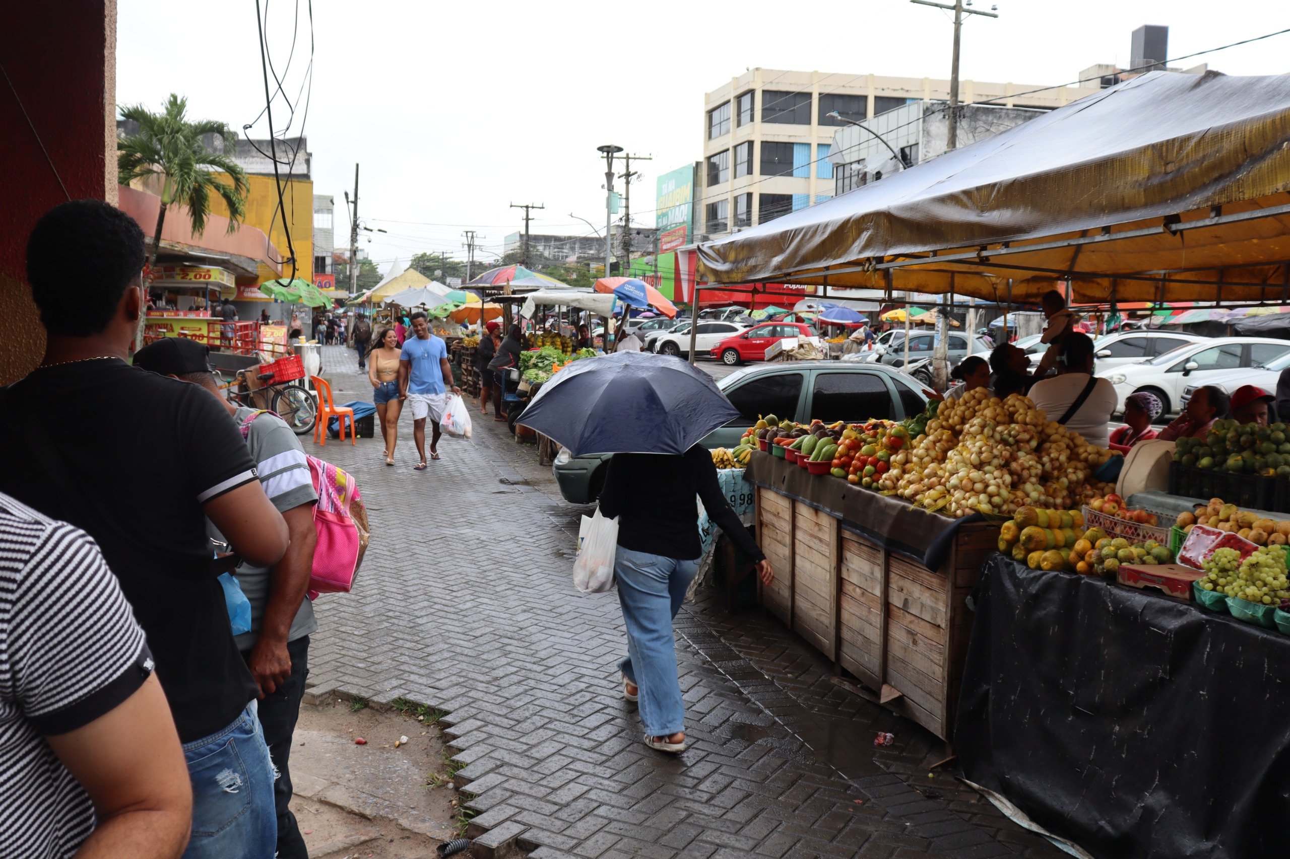 Pessoas caminhando no centro de Feira de Santana/Marechal Deodoro/Comércio/Mulher com guarda-chuva