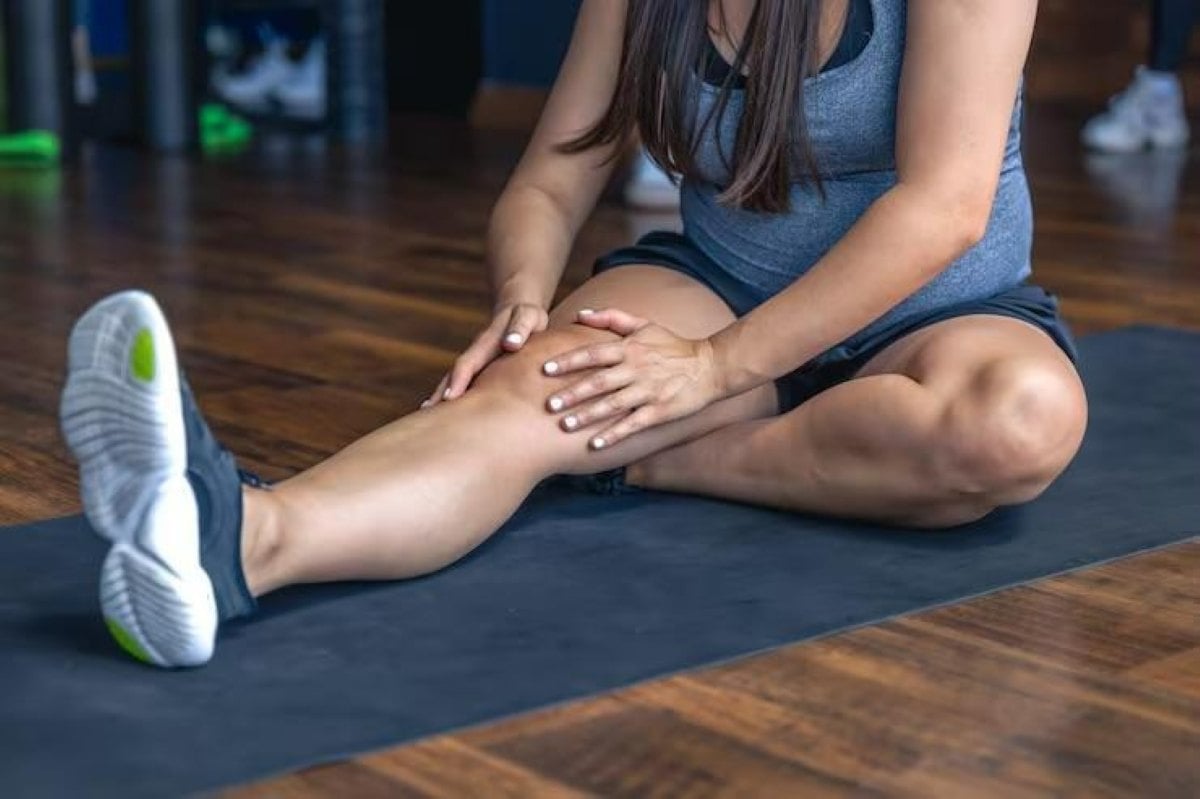 Mulher tocando no joelho