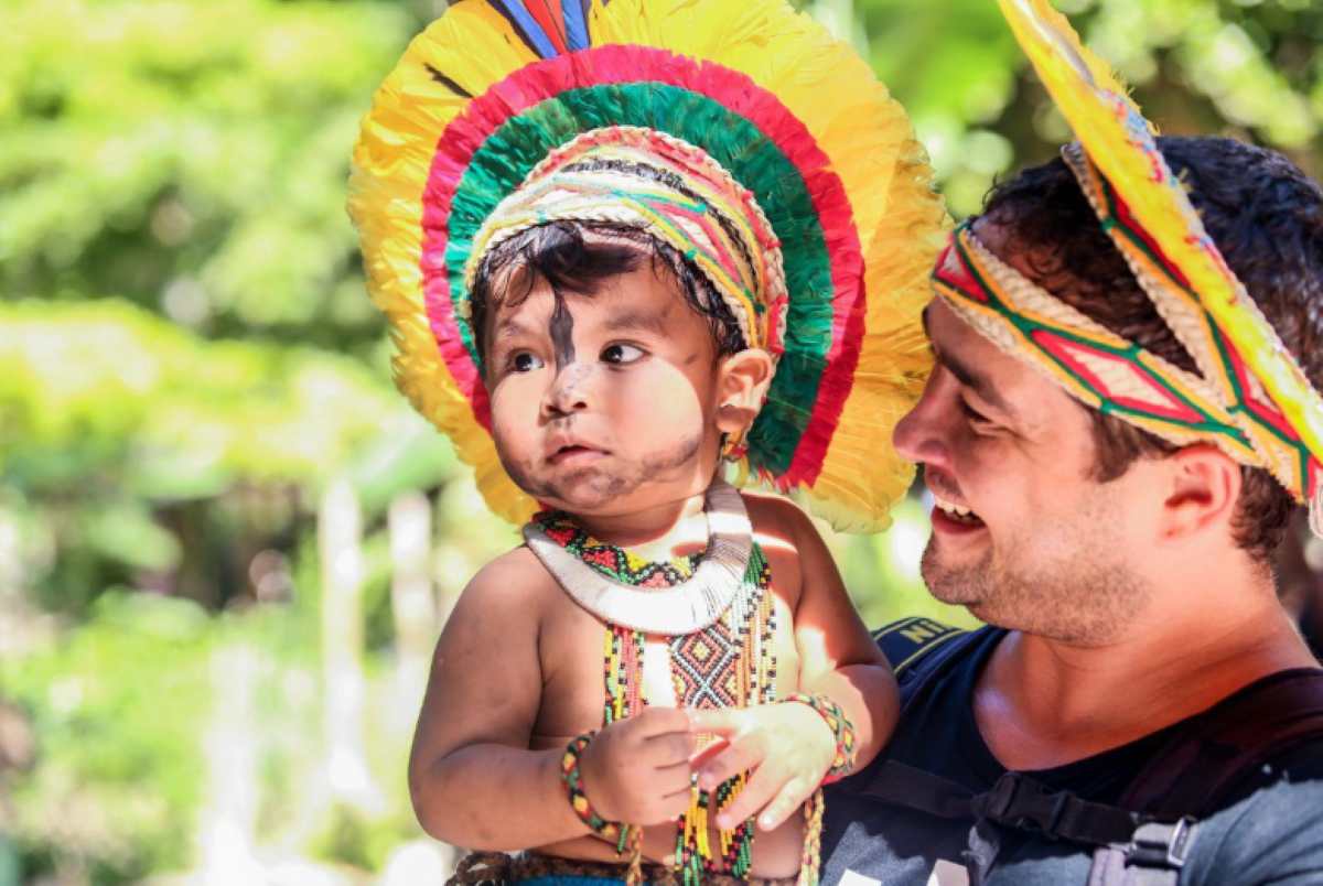 Fotógrafo Pedro Nunes interage com criança na Aldeia Pataxó da Jaqueira