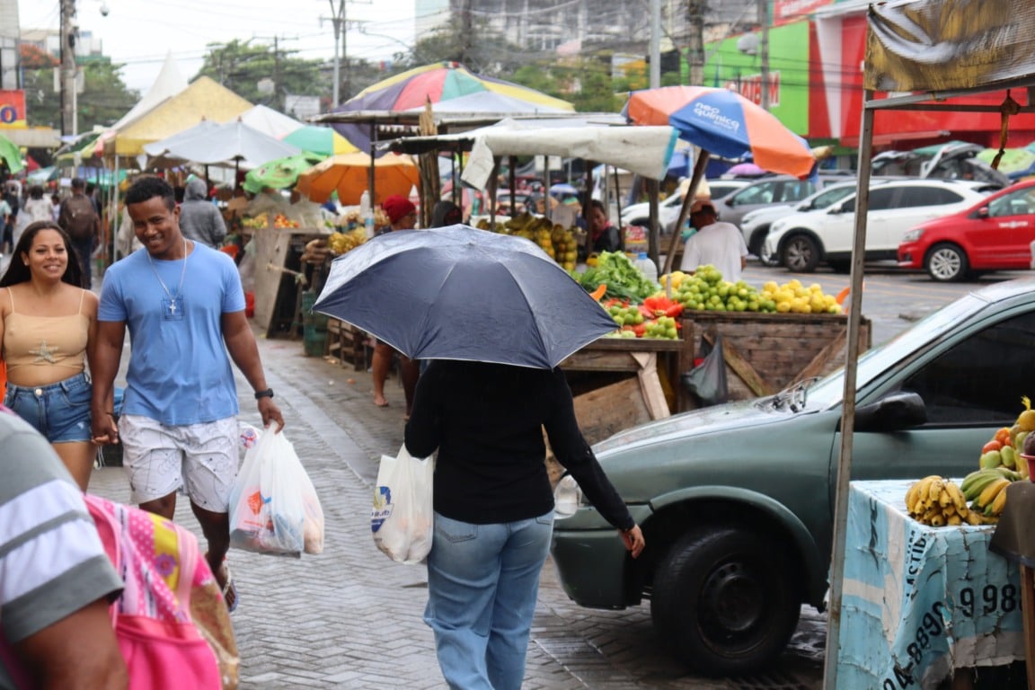 Pessoas caminhando no centro de Feira de Santana/Marechal Deodoro/Comércio/Mulher com guarda-chuva