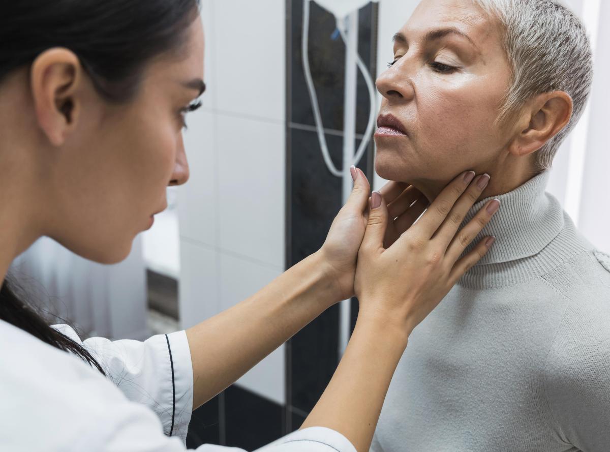 Médica verificando pescoço de paciente
