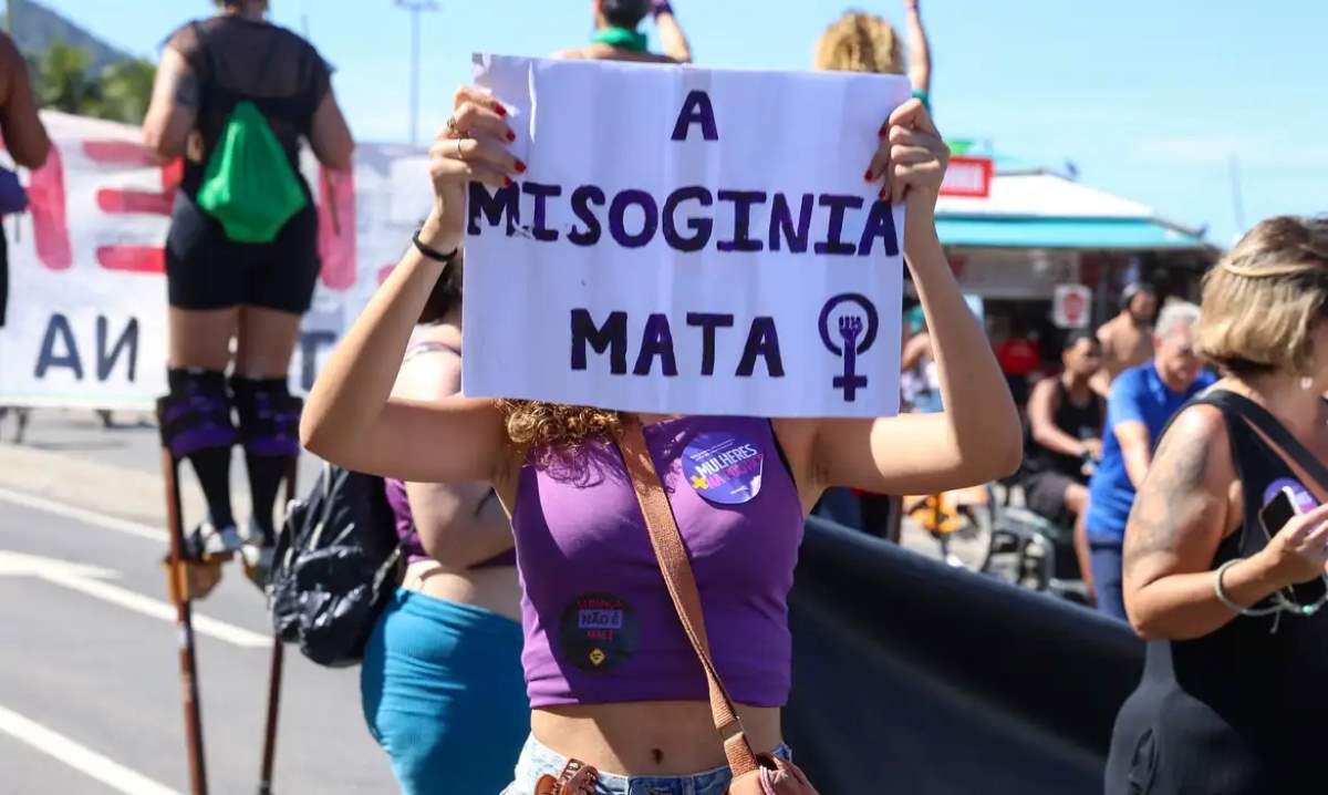 Mulher segurando um cartaz com o texto 'Misoginia mata'