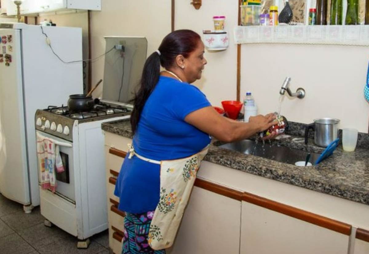 Dona de casa lavando pratos