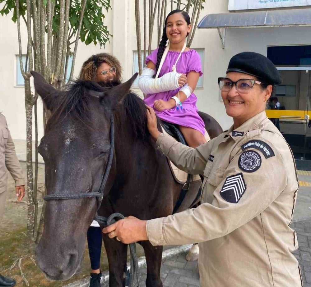 Policial, paciente do HEC e colaboradora do hospital interagem com cavalo Policial, paciente do HEC e colaboradora do hospital interagem com cavalo