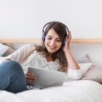 feliz-mulher-jovem-escutar-musica-cama_freepik-300x200-1