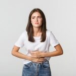 mulher-com-dor-de-estomago-curvando-se-e-com-as-maos-na-barriga-desconforto-de-colicas-menstruais
