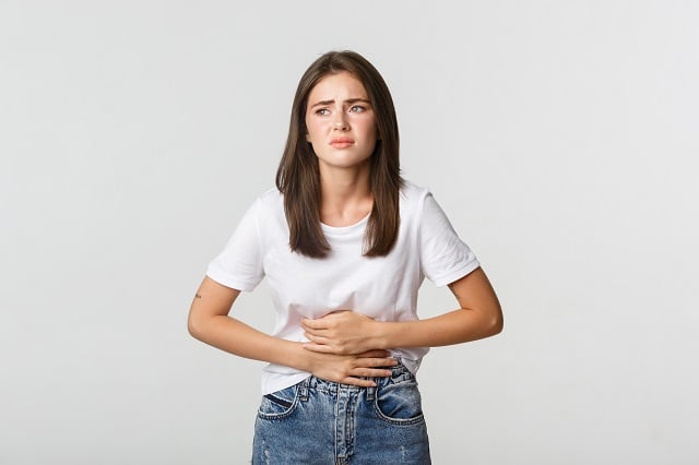 mulher-com-dor-de-estomago-curvando-se-e-com-as-maos-na-barriga-desconforto-de-colicas-menstruais