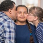 adolescentes_freepik_parents-kissing-daughter