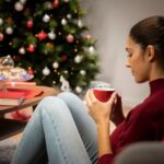 menina-olhando-um-copo-com-um-fundo-de-natal_23-2148332647