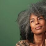 mulher-afro-de-cabelos-cinzentos-em-fundo-plano-verde-preto_841543-68019