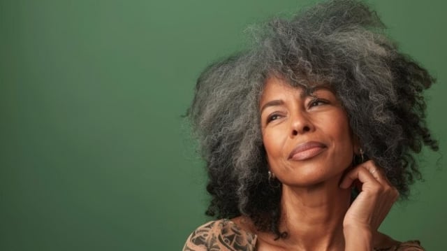 mulher-afro-de-cabelos-cinzentos-em-fundo-plano-verde-preto_841543-68019