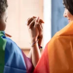 eaKRgVRJ-mulher-negra-africana-lgbt-cobrindo-a-bandeira-do-arco-iris-lgbtq-com-a-mulher-lgbt-asiatica-de-cabeca-para-baixo-conceito-de-movimento-de-orgulho-gay_46728-3091