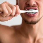 homem-escovando-os-dentes-com-creme-dental