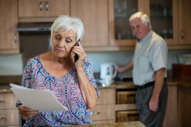 mulher-idosa-falando-ao-telefone-enquanto-homem-trabalha-na-cozinha-de-casa_-freepik