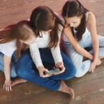 WQ01JlXN-tres-adolescentes-em-um-fundo-rosa-jogando-no-telefone-vicio-em-jogos-de-azar_154092-6500