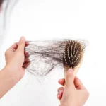 eDkXRSaO-a-mao-de-uma-mulher-agarra-o-cabelo-que-faltava-na-escova-isolada-no-fundo-branco_483511-7
