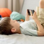 eKE2sQjo-medium-shot-boy-with-smartphone-crianca-com-o-celular-no-quarto-foto-freepik