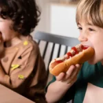 NOm7tEwi-criancas-comendo-cachorro-quente-juntas_23-2148914520-freepik