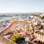 segurando-um-aviao-de-brinquedo-no-fundo-da-cidade-em-coimbra-durante-o-por-do-sol-no-centro-de-portugal_506452-9707