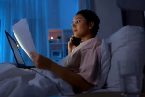 mulher-com-papeis-a-ligar-para-o-telefone-na-cama-a-noite_380164-270176