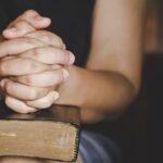 espiritualidade-e-religiao-as-maos-postas-em-oracao-sobre-uma-biblia-sagrada-na-igreja_1150-12794-1