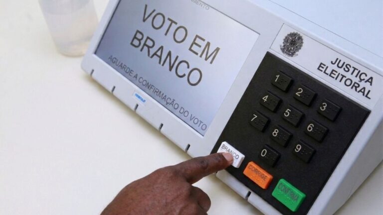 manual-do-eleitor-pessoa-apertando-o-botao-branco-da-urna-eleitoral-etetronica-voto-eleicoes-2026-foto-gerado-com-auxilio-de-IA
